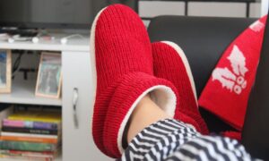 Comfortable relaxation at home with fluffy red slippers and a cozy setting. - Photo by Merve Sayın on Pexels